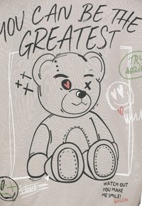 Grafisch ontwerp met een cartoon teddybeer met een gestikte uitstraling, een grijze achtergrond en speelse tekst in zwart en groen.