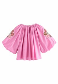 Haut rose à manches bouffantes avec encolure froncée, orné de broderies florales hexagonales sur les épaules. Le matériau semble léger et texturé.