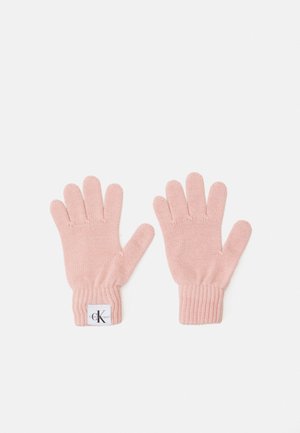Des gants tricotés en rose doux, avec un poignet côtelé et une petite étiquette avec un logo sur un des gants. Chaque gant a cinq doigts.