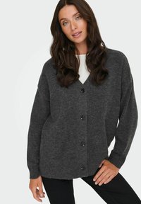 Cardigan grigio scuro realizzato in morbido tessuto a maglia, con scollo a V, maniche lunghe e cinque bottoni neri sul davanti.