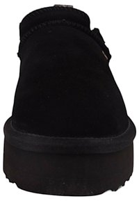 Czarne buty wsuwane o zamszowej fakturze, okrągłym nosku i grubej czarnej gumowej podeszwie. Posiadają przeszywany brzeg i minimalne akcesoria.
