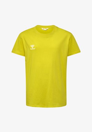 To børn står side om side iført gule t-shirts, sorte og grå shorts og sportssko mod en ensfarvet baggrund.
