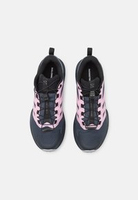 Mustat ja pinkit juoksukengät, joissa on verkkopäällinen, tekstuuri ja turvallinen nauhoitusjärjestelmä. Suunniteltu pehmustetulla pohjalla mukavuutta varten.