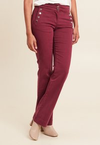 Bordeaux katoenmengsel broek met metallic knoopdetails op de zakken en een recht pijpdesign, gecombineerd met beige blokhakschoenen.