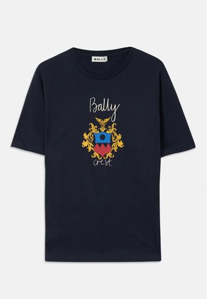 Navy blue cotton T-shirt featuring a colorful crest graphic with an eagle, circular design, and text "Bally Crest" in white and gold accents.