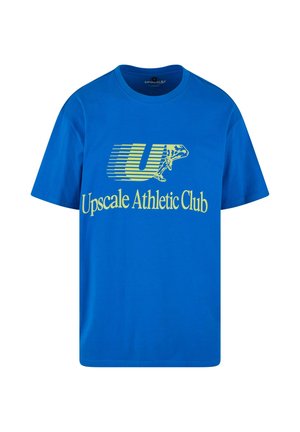 Blaues Baumwoll-T-Shirt mit einem grafischen Design und gelbem Text, der "Upscale Athletic Club" sagt, sowie einem stilisierten "U"-Logo.