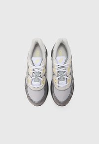 Pair of gray, white, and beige ASICS running shoes with white laces, viewed from above on a plain light gray background.