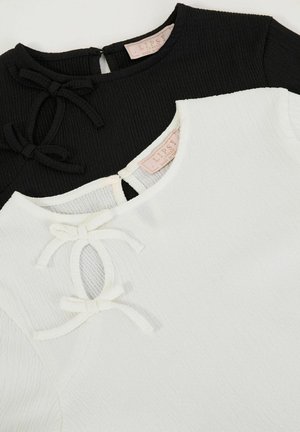 Juoda ir balta viršutinė dalis su šiurkščiu tekstūru, trumpomis rankovėmis, apvaliu iškirpimu ir dekoratyvinėmis kaspinėmis prie priekinio atidarymo.