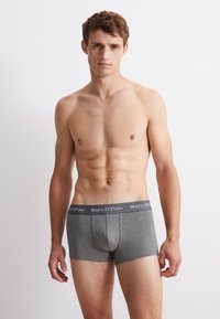 Graue Baumwollboxershorts mit körperbetontem Design, elastischem Bund mit "Marc O'Polo"-Logo, glatter Textur und einer Länge bis zur Mitte des Oberschenkels.