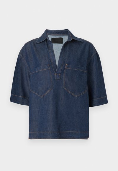 Σκούρο μπλε κοντομάνικο τζιν πουκάμισο με ευρύ V-λαιμόκοψη, γιακά και δύο μπροστινές τσέπες στο στήθος με ορατές ραφές.
