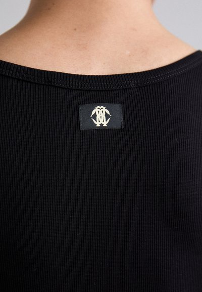 Must mustriga kangast sleeveless särk, millel on ümar kaelus ja kreemivärvi logosilt selja taga. Sile kangas, millel on kerge venivus.