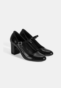 Zwarte gepatineerde leren high heels met een vierkante hak, ronde neus en een dunne band met een zilveren gesp. Gevoerde details op het lichaam.