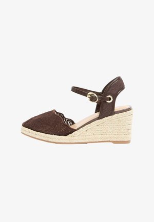 Sötétbarna ék talpú szandál hímzett zárt orral, arany csattal ellátott boka pánttal és fonott, juta platform talppal.
