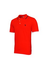 Punainen puuvillapaita, jossa on perinteinen kaulus, kaksinappinen etumus ja erottuvat siniraitaiset yksityiskohdat hihansuissa.