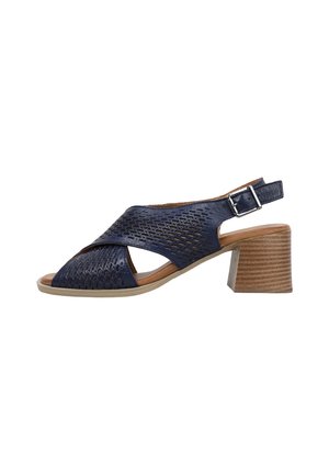 Sandale bleu marine à bout ouvert avec empeigne en cuir perforé, bride de cheville ajustable et talon bloc empilé en marron clair.
