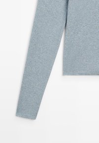 Maglione azzurro chiaro a maniche lunghe con texture a coste, scollo rotondo e orlo dritto. Realizzato in un morbido tessuto elasticizzato.