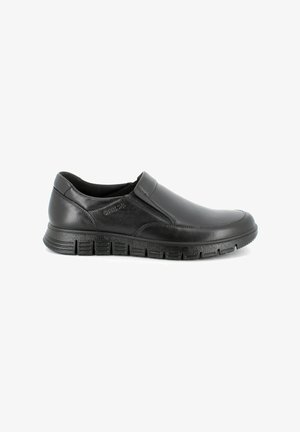 Scarpa slip-on in pelle nera con punta arrotondata, finitura liscia, suola imbottita e suola in gomma testurizzata con scanalature per una migliore aderenza.