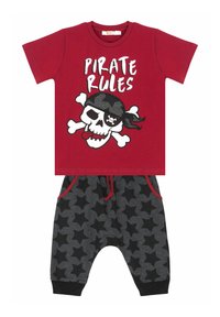 Rød T-shirt med teksten "Pirate Rules" og et kraniumgrafik. Sorte og grå stjerne-mønstret bukser med rød snor og lommer.