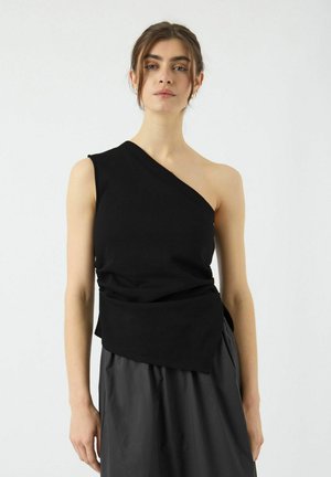 Asymmetrisk sort top i strækbart stof med en skulderdesign og draperinger i taljen, parret med en tekstureret grå nederdel.