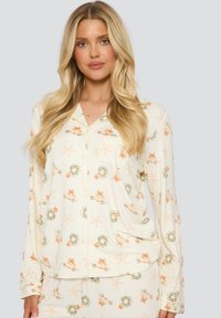Leichtes Cremepijama-Set mit einem sich wiederholenden Muster aus Sternen, Kränzen und Schleifen. Aus weichem Stoff, mit Knopfleiste und langen Ärmeln.