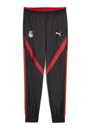 Pantalons de sport noirs avec des rayures diagonales rouges, taille élastique et poignets. Présente des patches de logo sur la cuisse gauche et la partie supérieure de la jambe. Fabriqué en matériau lisse.