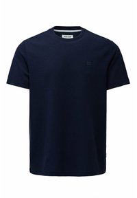 Camiseta de manga corta en azul marino de tejido texturizado, con escote redondo y un pequeño parche de logotipo cuadrado en la parte frontal.