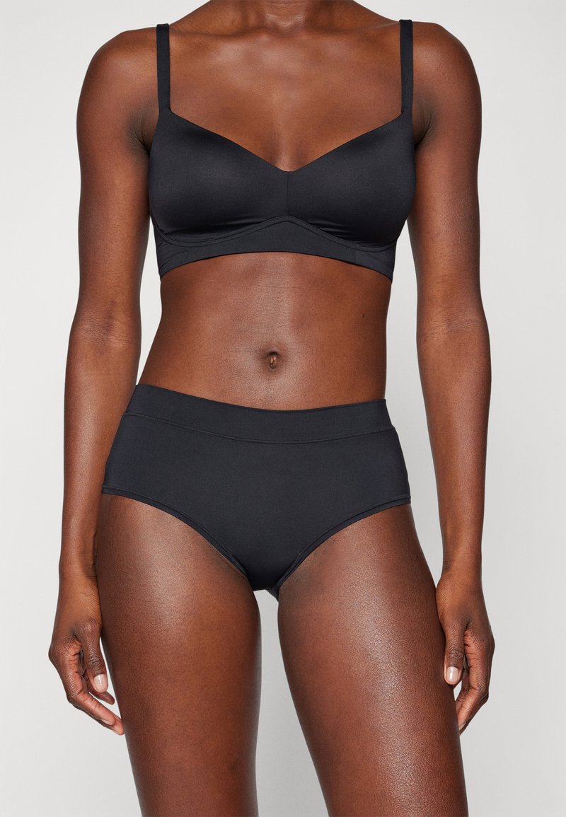 Black lingerie set featuring a seamless bralette with thin straps and a matching high-waisted brief; smooth fabric with minimal detailing.
