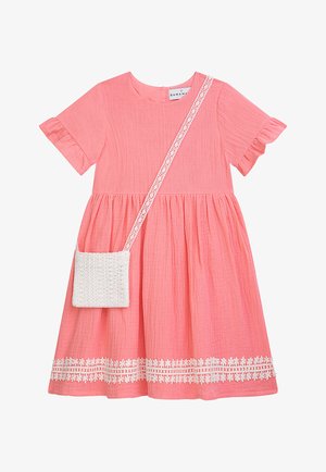 Korallenrosa kurzärmeliges Kleid mit Rüschensäumen, floralem Saumabschluss und weißer gehäkelter Umhängetasche mit Spitzenträger.