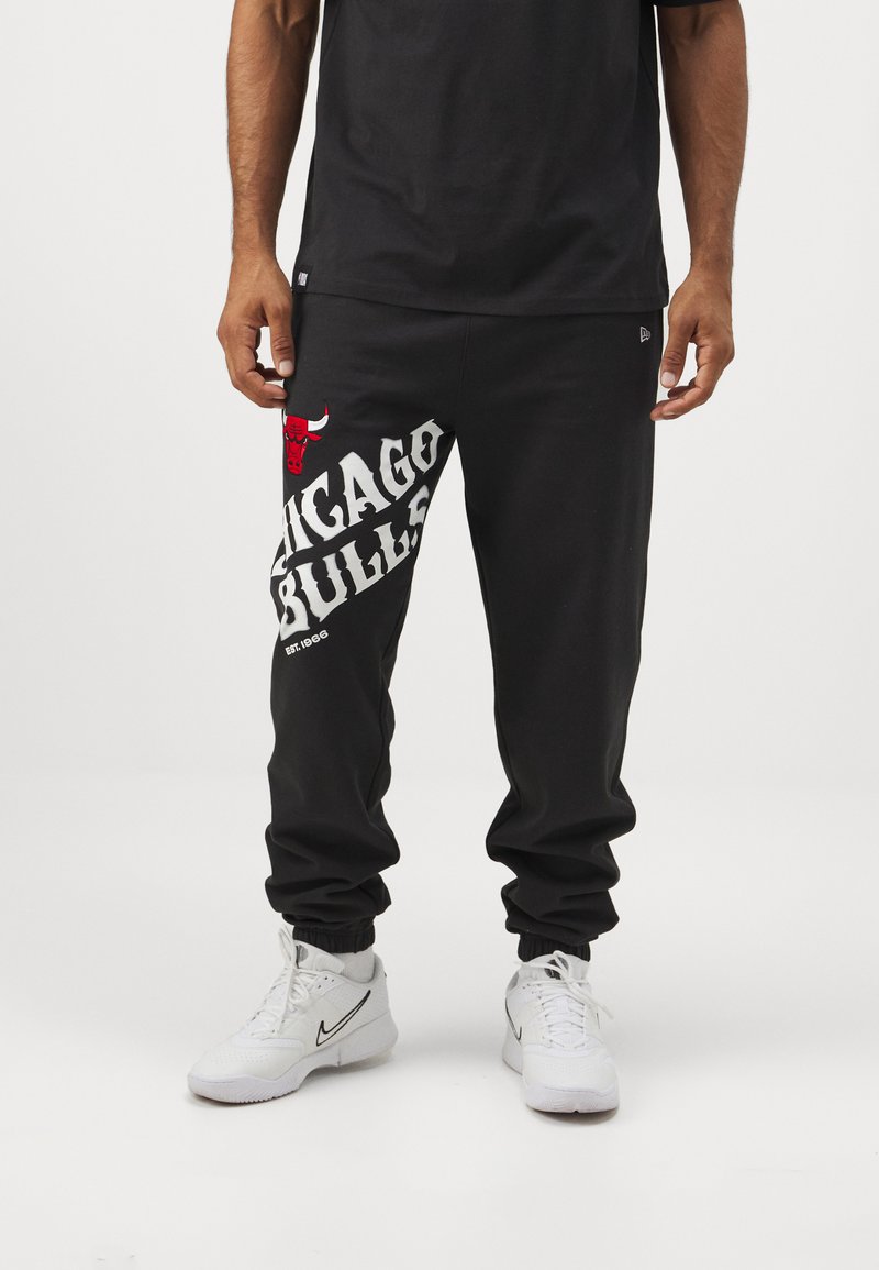 Pantaloni tuta neri con logo rosso dei Chicago Bulls e testo bianco audace sulla gamba sinistra, con fondo elastico e vestibilità rilassata.