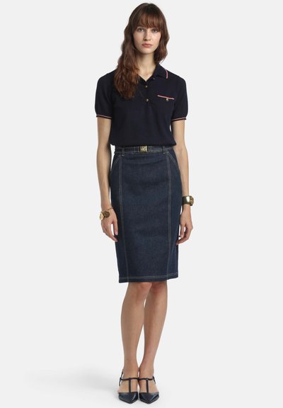 Tricou polo bleumarin cu mâneci scurte și accente cu dungi roșii, asortat cu o fustă conică din denim închis la culoare, cu cusături contrastante și curea în talie.