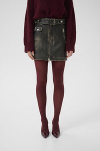 Black leather mini skirt with a front zipper, two side pockets, and a belt. Worn with burgundy tights and glossy burgundy heels.