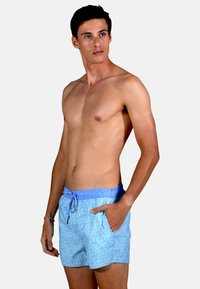 Bermuda de bain bleu clair avec un motif, taille ajustable avec cordon de serrage, poches latérales et texture de tissu douce.