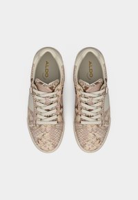 Paire de baskets au motif peau de serpent crème et brun clair avec des lacets beiges et la marque ALDO à l'intérieur.