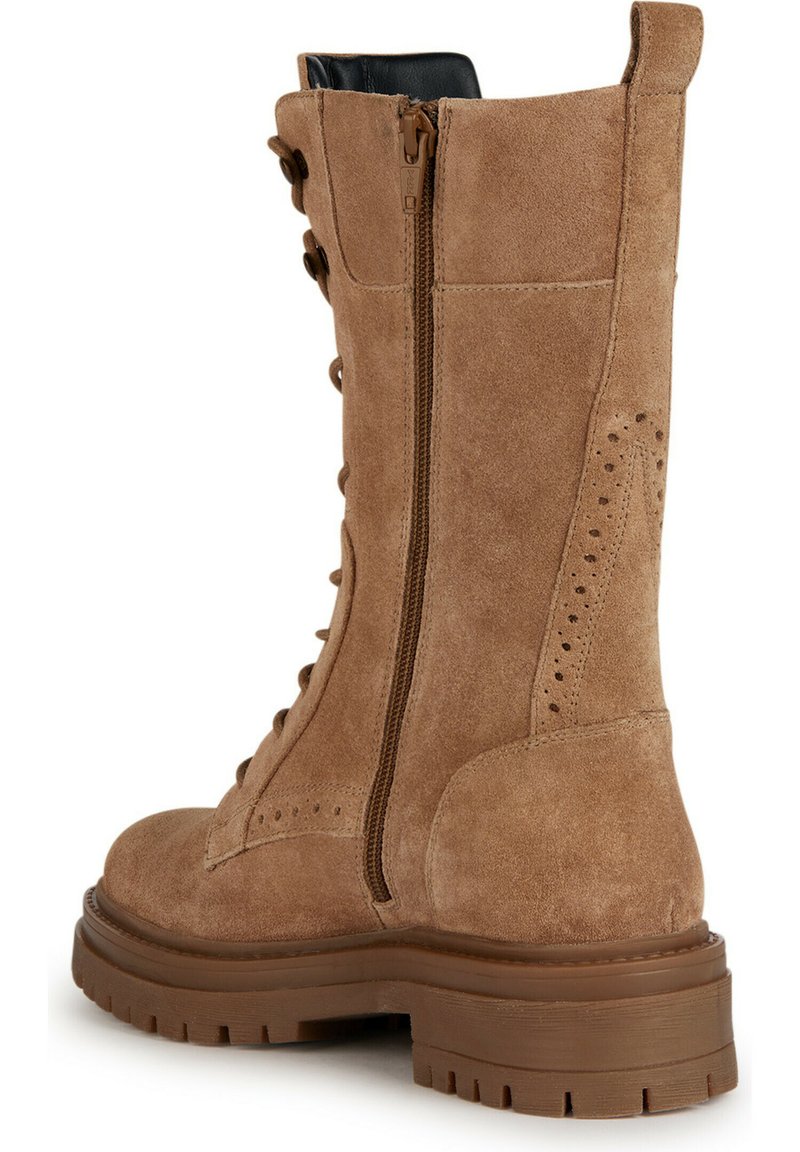 Bruine suède veterschoen met een zijrits, chunky rubberen zool en geperforeerde details op het bovenste gedeelte.