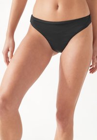 Svart bikiniunderdel med en minimalistisk design, låg midja, slät textur och rena linjer. Inga synliga mönster eller hårdvarudetaljer.