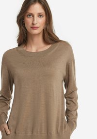 Brun, lätt vikt tröja med rund halsringning, långa ärmar och ribbade manchetter. Mjuk textur med en lätt lyster, avslappnad passform.