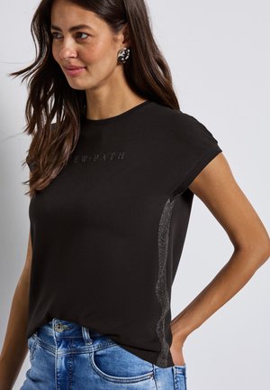 Zwarte T-shirt met korte mouwen en reliëftekst "NEW PATH"; heeft een glinsterende textuur langs de zijnnaad; zacht materiaal.