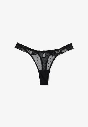 Tanga negra de malla transparente con puntos, con un borde de encaje y un acabado en forma de olas. Textura suave con acentos decorativos de hardware.