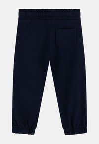 Pantalones de chándal de color azul marino con cintura elástica, puños fruncidos y un bolsillo trasero. Fabricados en una tela suave con una textura lisa.