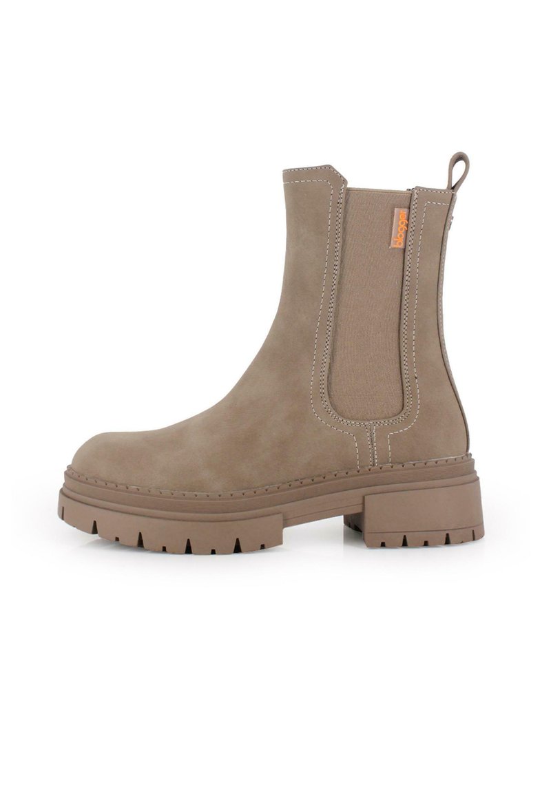 Bota beige de tobillo con un acabado de ante suave, paneles elásticos laterales, costuras de contraste y una suela de goma gruesa y texturizada.