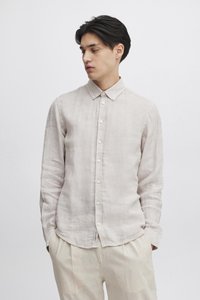 Lys beige lin-skjorte med knapp-på-krage, lange ermer og knappelukking foran. Myk tekstur, minimalistisk design og ledig passform.