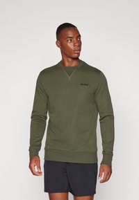 Sudadera verde oliva hecha de una tela suave, con cuello redondo, mangas largas y un logo negro de "BORG" en el pecho.
