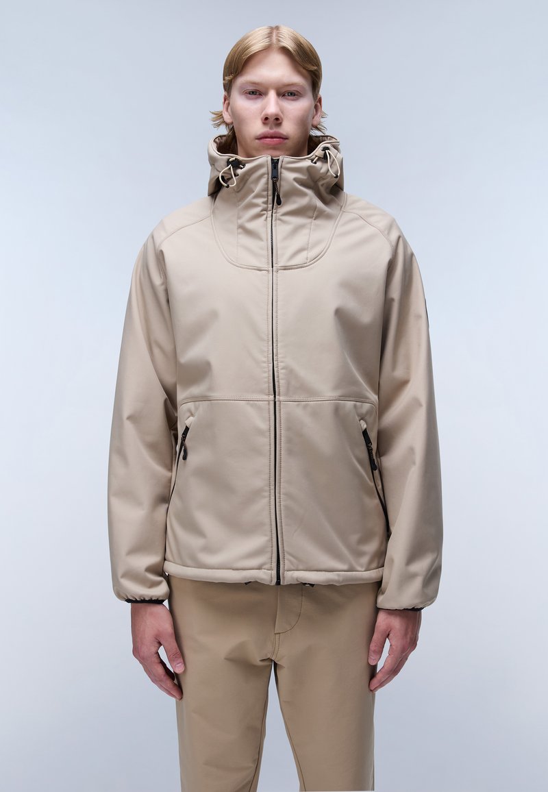 Beige vattentät jacka med hög krage, dragkedja fram och justerbar huva. Har också dragkedjefickor och en elegant, slät textur.