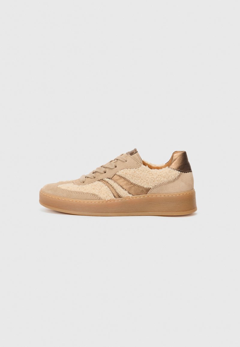 Baskets beiges avec un upper texturé en matériau ressemblant à de la fourrure et des accents en cuir. Semelle en caoutchouc, bout rond et lacets plats.