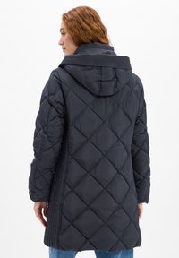 Langer, dunkelgrauer gesteppter Daunenmantel mit Kapuze, der diagonale Nahtmuster aufweist. Die Textur scheint glatt mit strukturierten Akzenten zu sein.