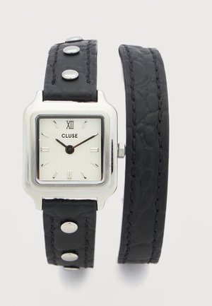 Čtvercové stříbrné hodinky s bílým ciferníkem, černými hodinovými a minutovými ručičkami, černým koženým dvojitým páskem s stříbrnými cvočky.