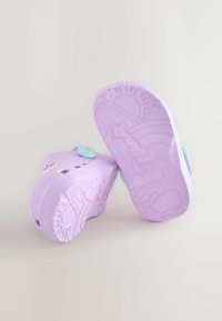 Scarpe viola per bambini con suole strutturate con motivi animali, bottoni laterali regolabili e fori di ventilazione per una migliore traspirabilità.