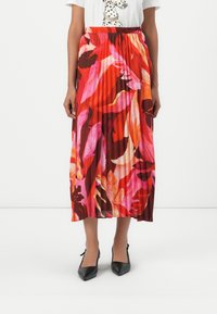 Plisserte midiskjørt med et dristig blomstermønster i rødt, rosa og brune nyanser, med elastisk midje og en luftig design.