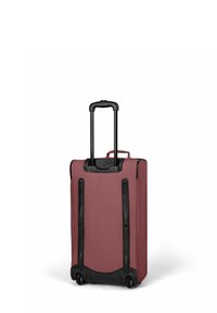 Valise à roulettes de couleur bourgogne avec une texture lisse. Elle dispose d'une poignée télescopique noire, de deux roues et d'une base robuste.