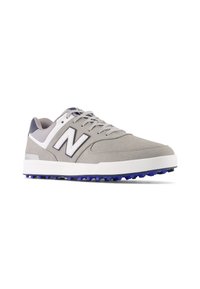 Scarpe sportive in suede grigio con accenti bianchi, caratterizzate da un prominente logo "N", design con lacci e suola in gomma viola testurizzata.